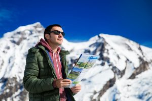 Tourist on the background of snowy mountains